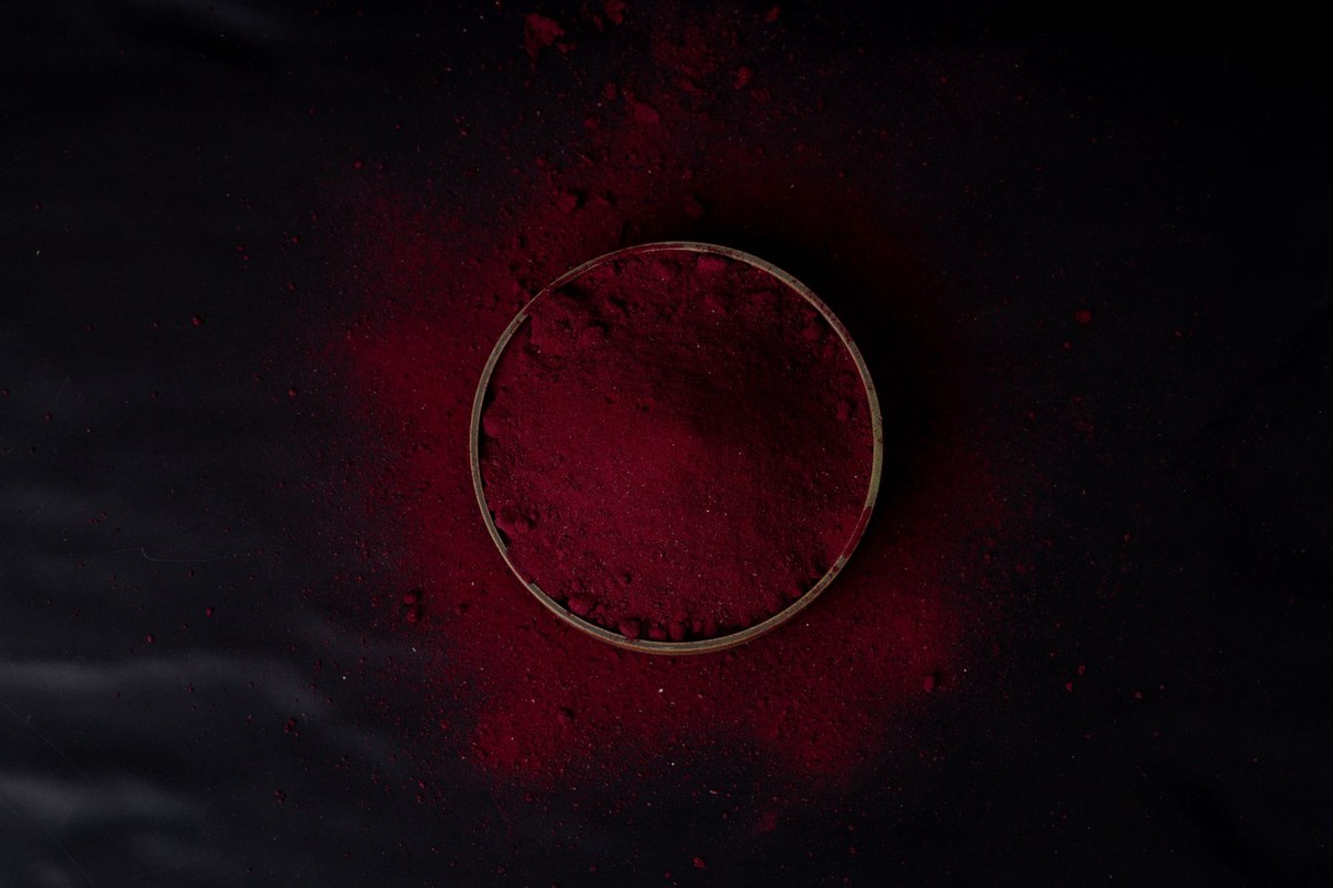 Crimson beetroot powder in a wooden bowl with splash